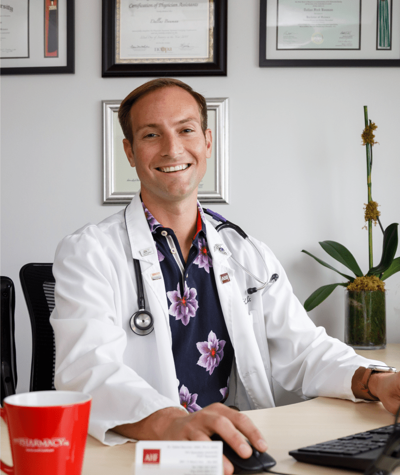 A doctor from AHF smiling in front of his desk
